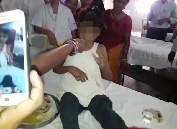 A young Indian girl sits on a bed in a hospital in this image taken from video in Bahraich northern India