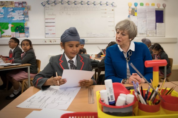 Conservative party leader Theresa May with eight year old Akaal Singh as she meets pupils at Nishkam Primary School in Birmingham, during a general election campaign visit to the West Midlands.