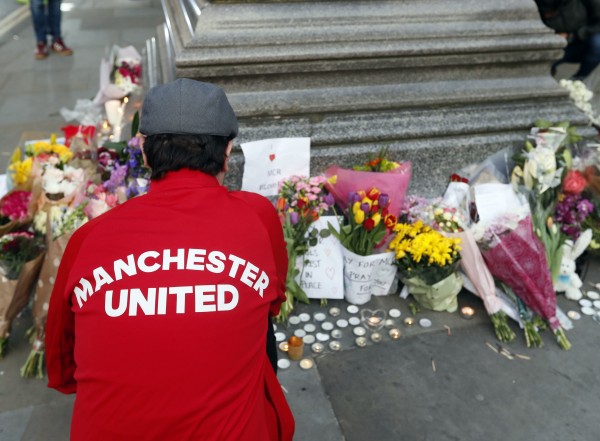 People lay flowers after a vigil in Albert Square