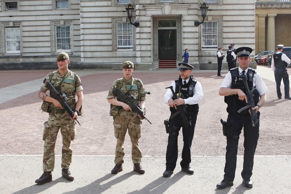 Soldiers join police officers outside Buckingham Palace.