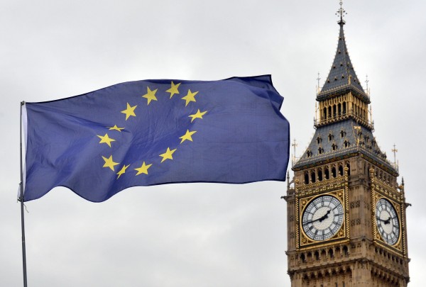 an EU flag flying in front of the Houses of Parliament