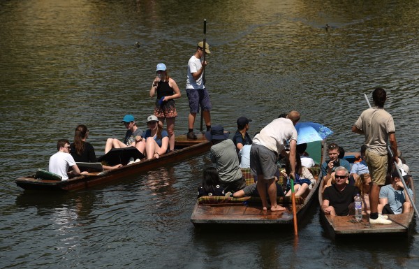 People relax in punts along the River Cam in Cambridge (Joe Giddens/PA)