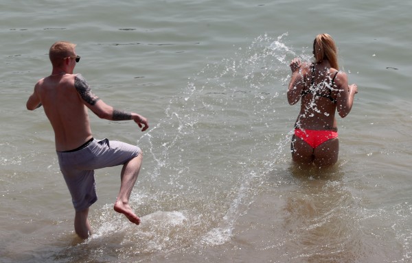 People enjoy the hot weather on the beach in Brighton (Gareth Fuller/PA)