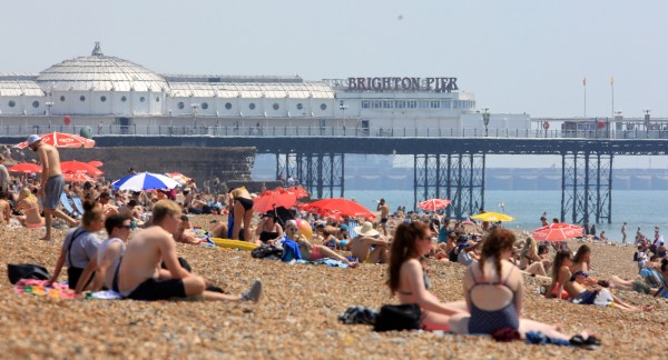 People enjoy the hot weather on the beach in Brighton (Gareth Fuller/PA)