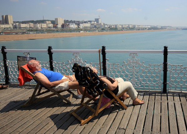 A couple enjoy the hot weather on the pier in Brighton (Gareth Fuller/PA)