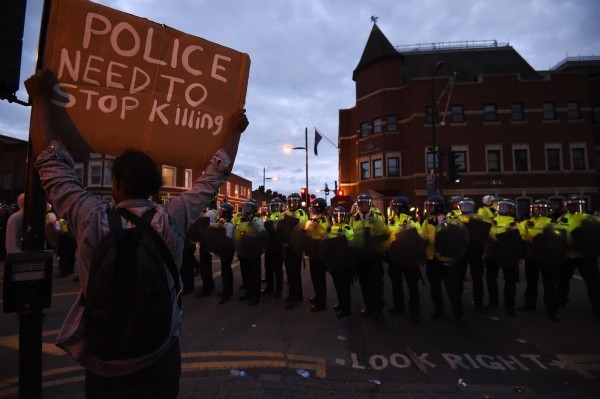 A lone protester with a sign in front of police