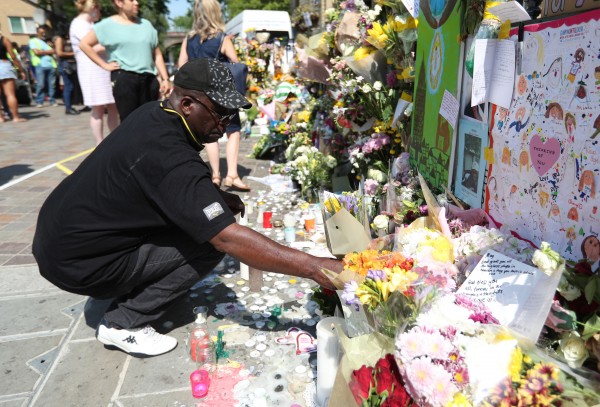 A man lays flowers outside Notting Hill Methodist Church